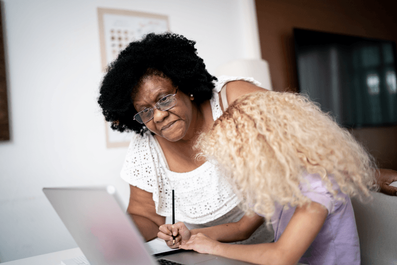 Grandmother helping granddaughter with homeschooling - stock photo
Grandmother helping granddaughter with homeschooling