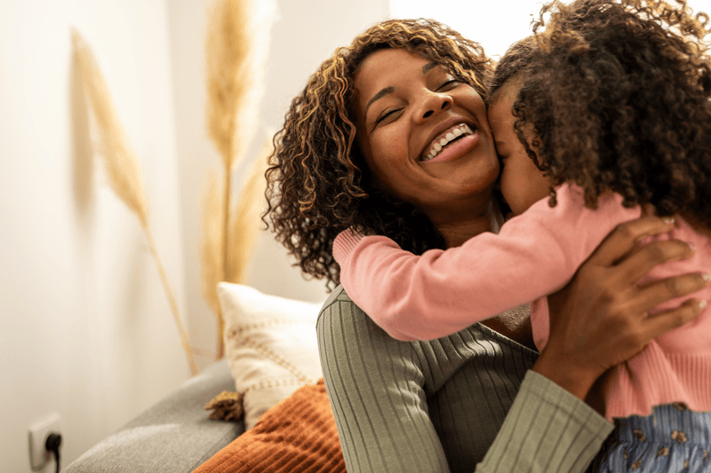 Close up of mother and daughter hugging - stock photo
Close up portrait of mother and daughter hugging, they are in the living room